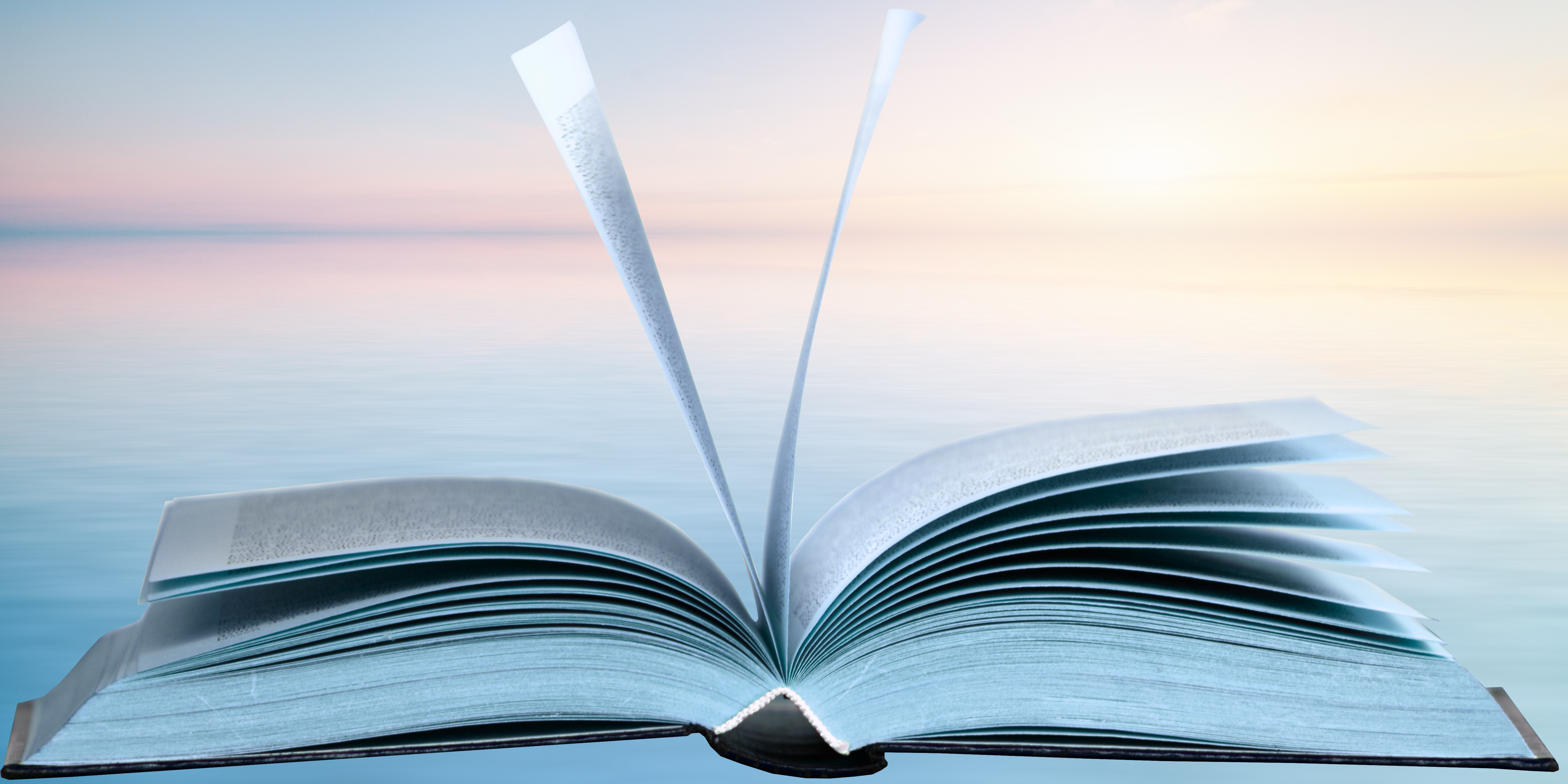 Image of an open book laying on a table pages with pages moving 
