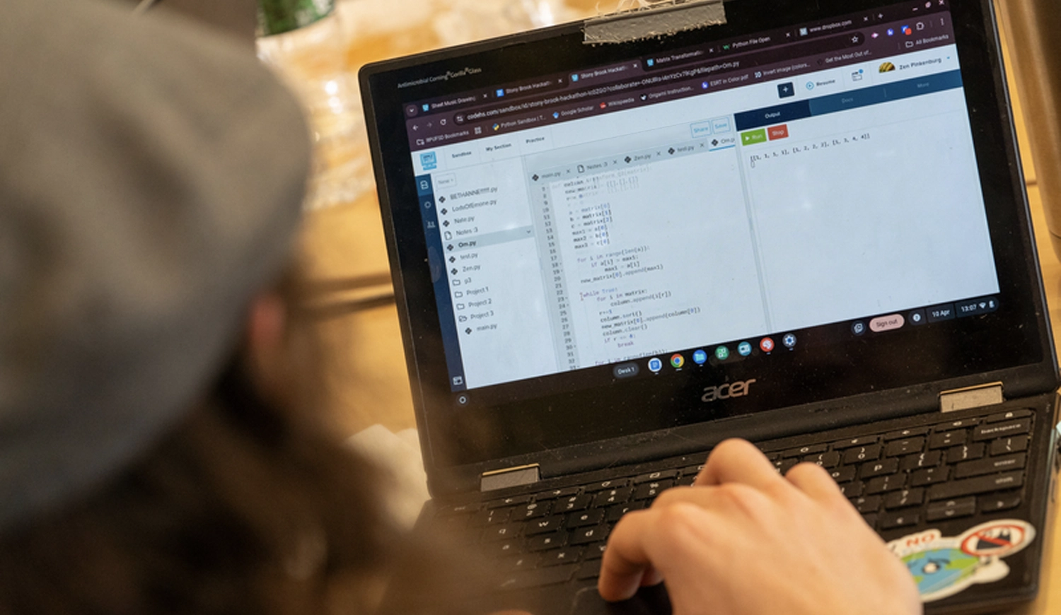 SUNY Stony Brook University College of Business Student on their laptop coding using python coding language
