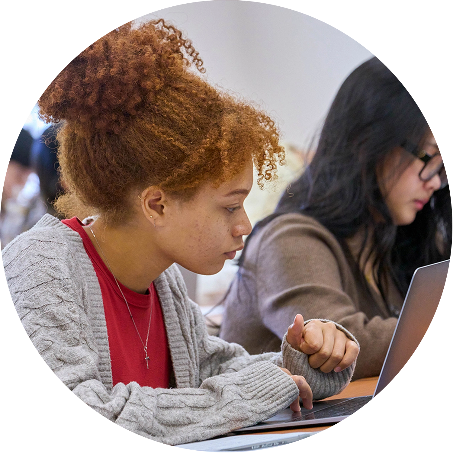 Two College of Business Students focusing on their classwork while attending a lecture