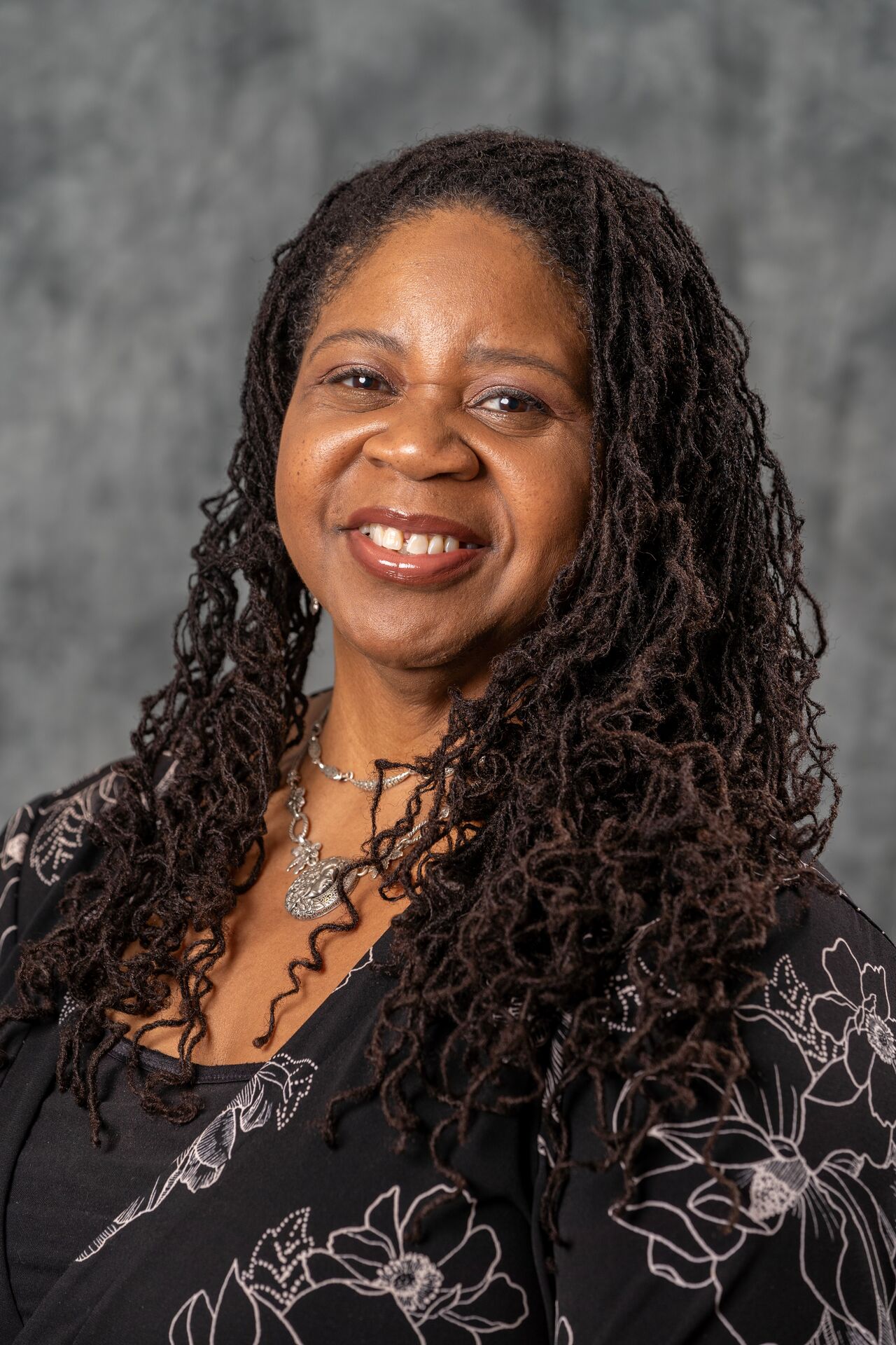 Lois Carter, with long curly hair, smiling 