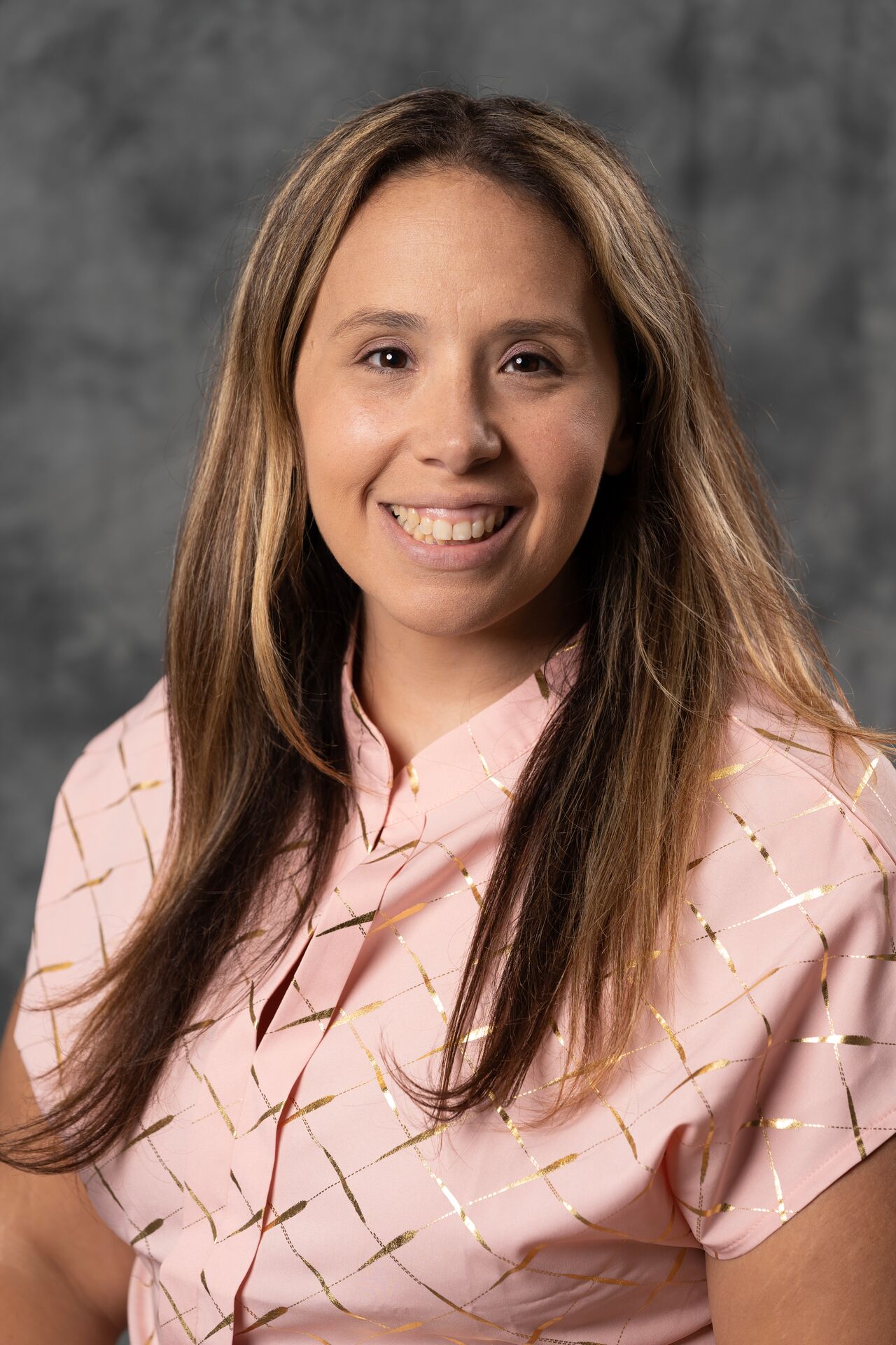 Danielle Papaspyrou, wearing a pink collared shirt and smiling