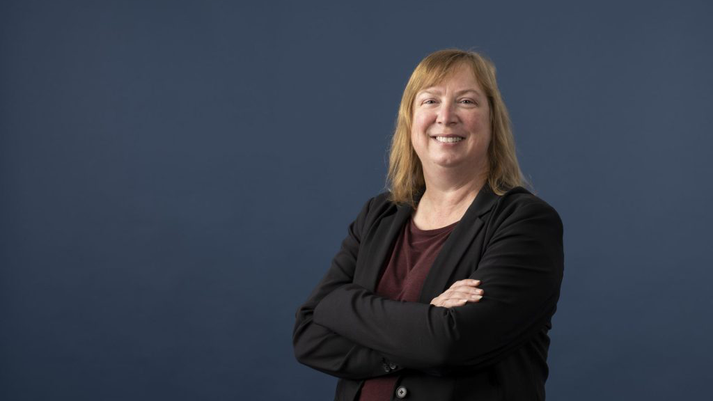 Shelley Minteer Shelley Minteer, with shoulder-length blonde hair, wearing a suit and red shirt