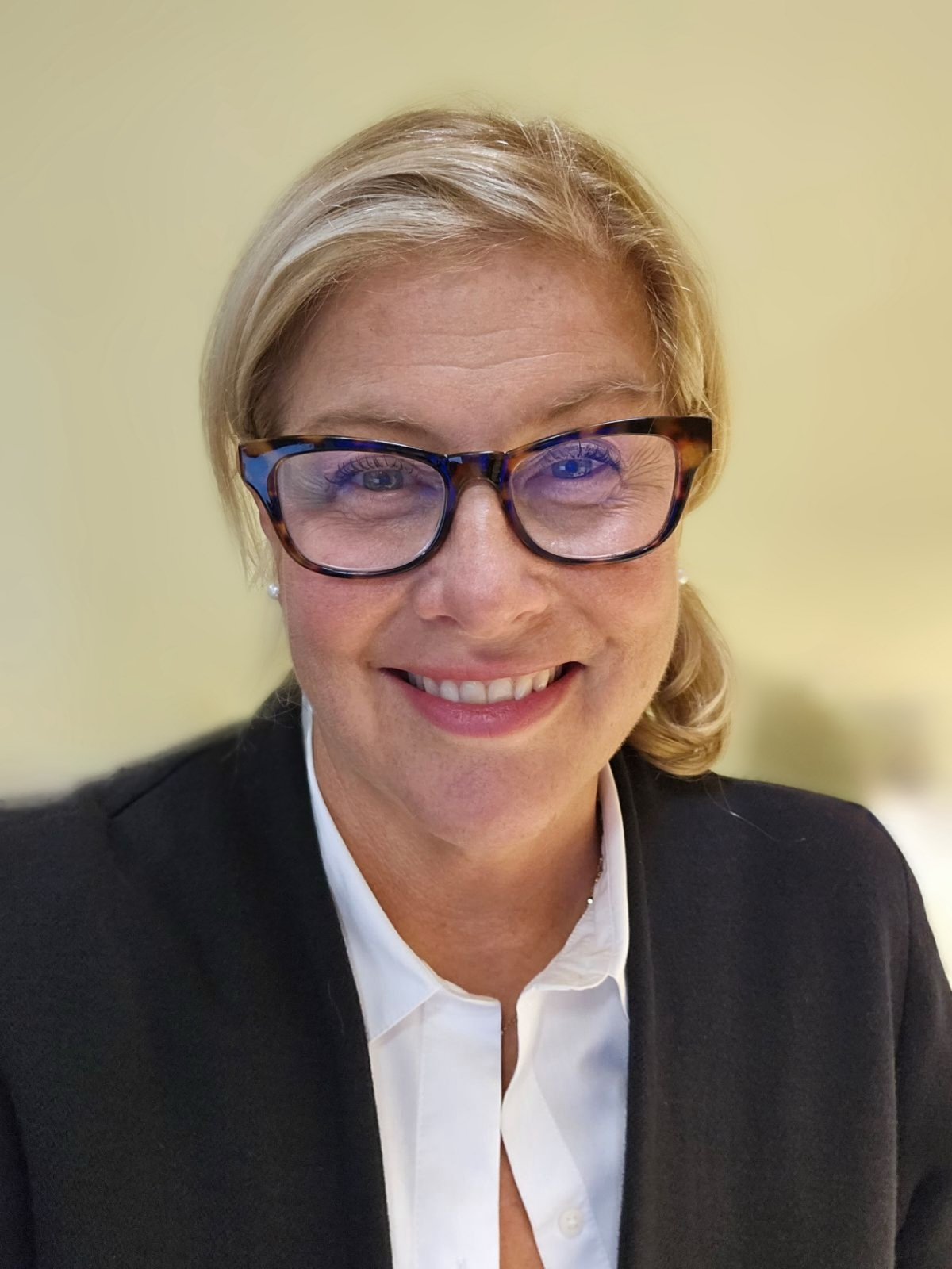 Hilary Noren, wearing a black suit jacket and white collared shirt