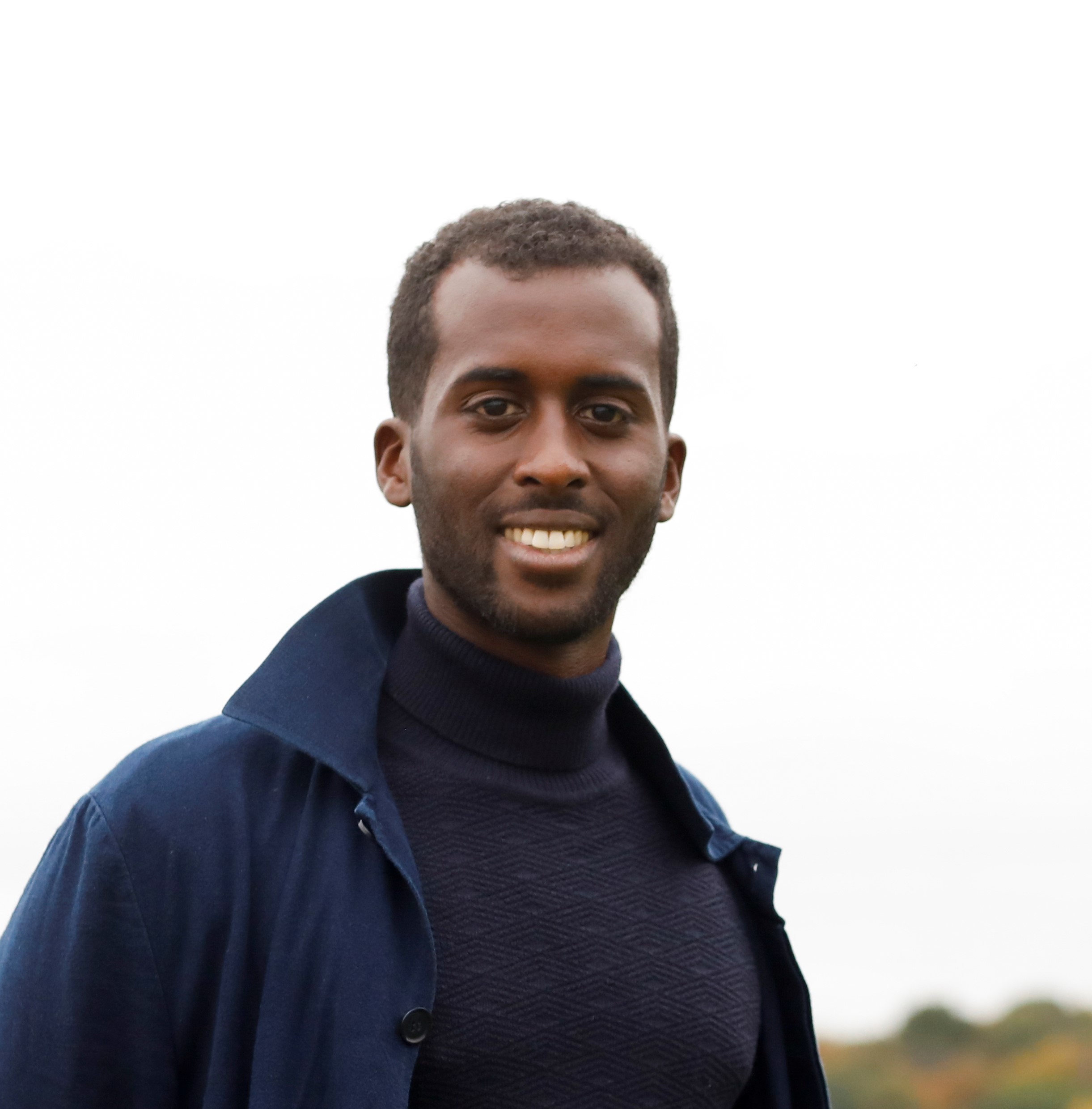 Male wearing a Blue coat poses outdoors