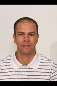 Portrait of an individual wearing a striped shirt, set against a plain background.