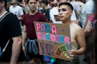 Person at a Pride parade holding a sign that reads "PARA ESCOGER AMAR.
