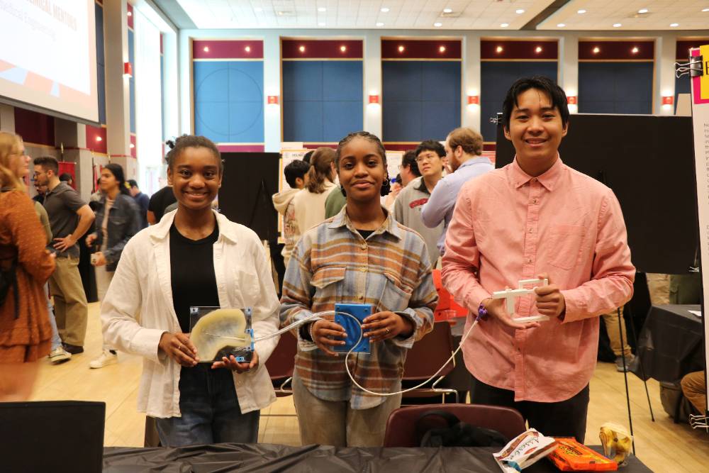 Three students holding new feeding tube design