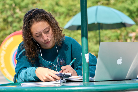 Student studying outside with a laptop
