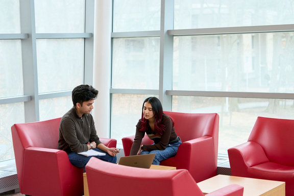 Two students talking in a lounge