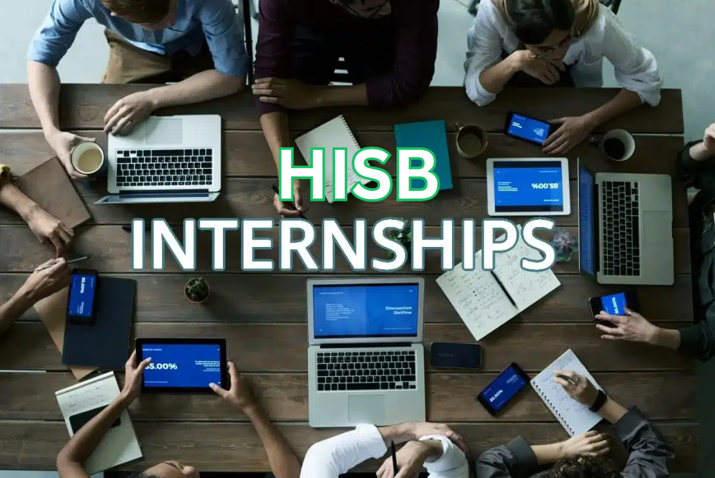 Photo of people sitting around a table working on computers