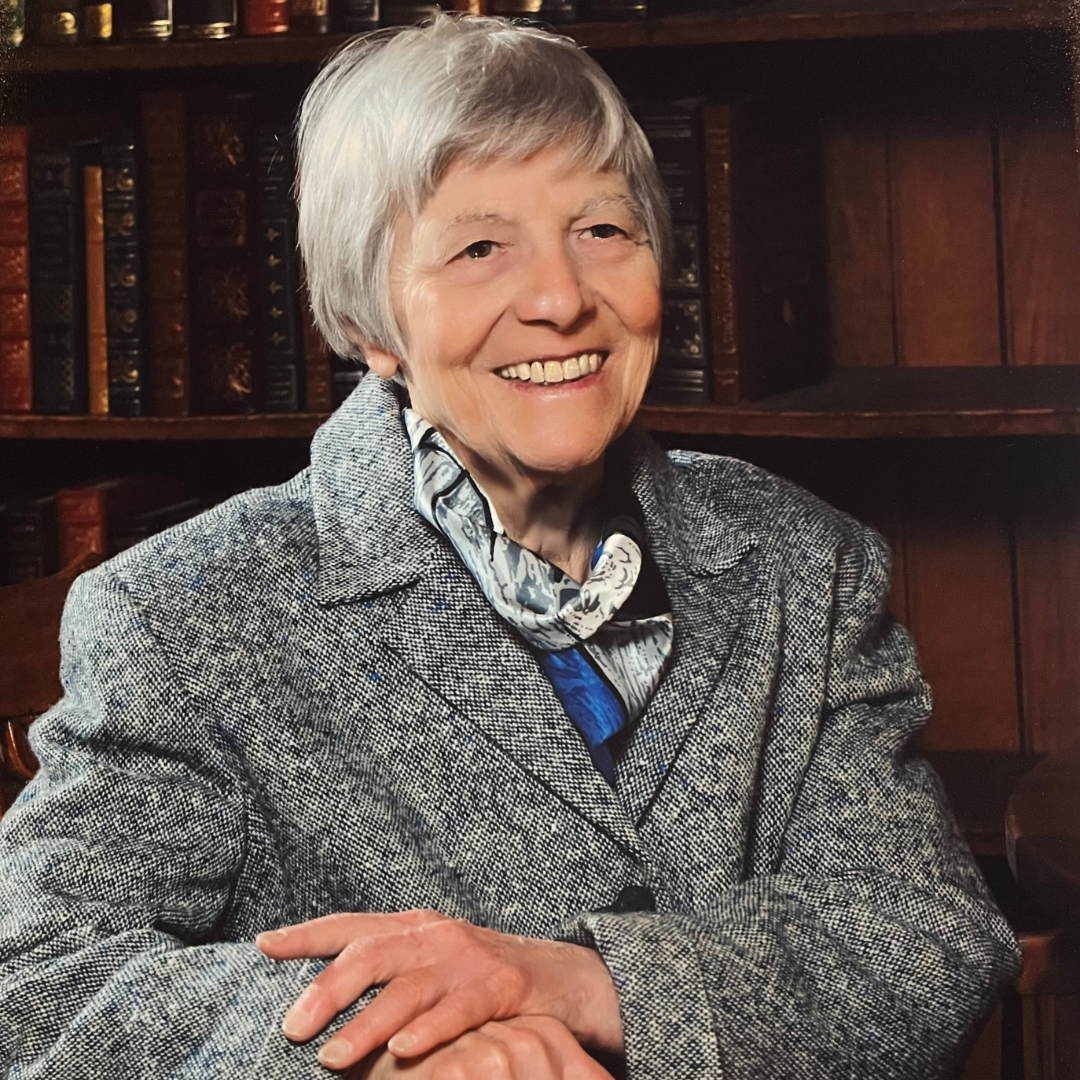 Dina G. Malgeri headshot image Dina G. Malgeri on a background of bookshelves